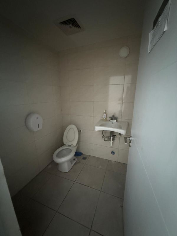 Simple tiled bathroom with sink toilet in commercial building Panama City Rio Abajo