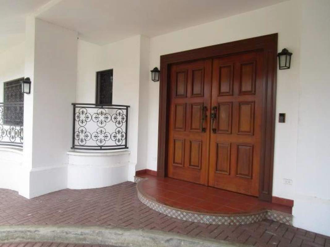 Mediterranean style luxury house exterior with tiled roof, driveway and covered carport in Altos del Golf Panama