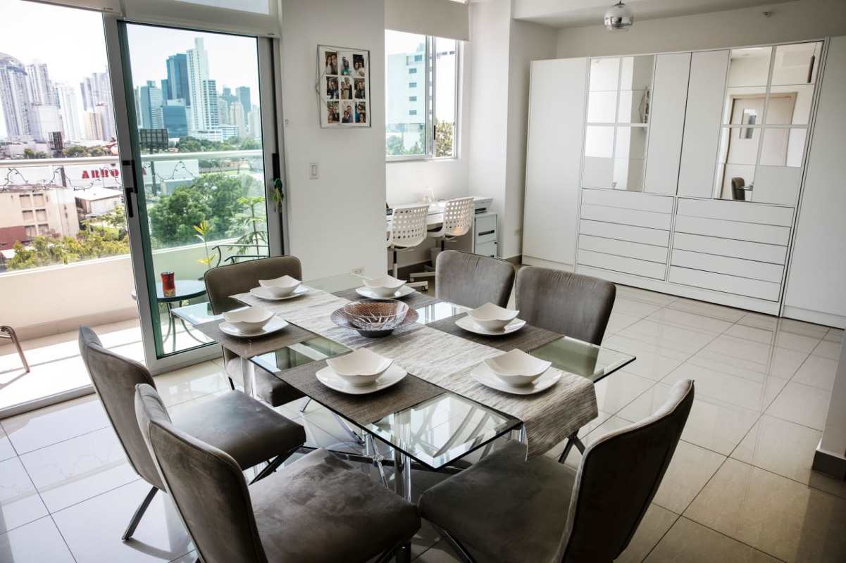 Open-plan dining area with large glass doors to balcony, skyline views in San Francisco Bay Panama