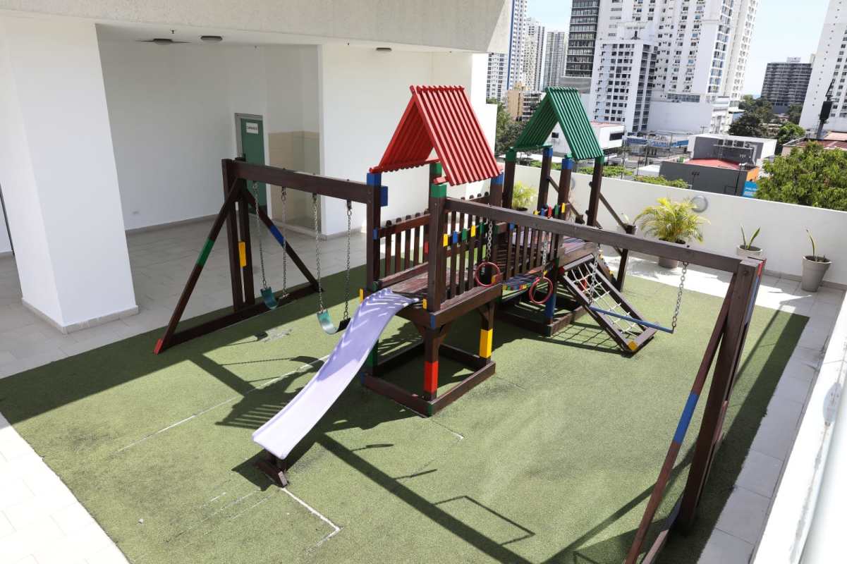 Rooftop playground with turf and colorful playsets at PH San Francisco Bay Panama City