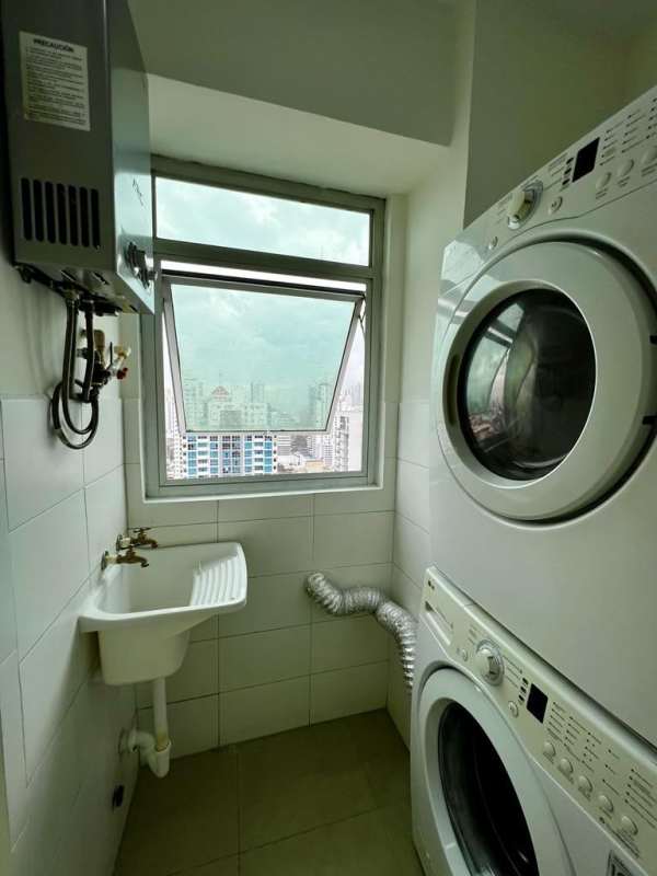 Laundry with stacked washer, heater, window with city view, PH Club de Golf Panama City