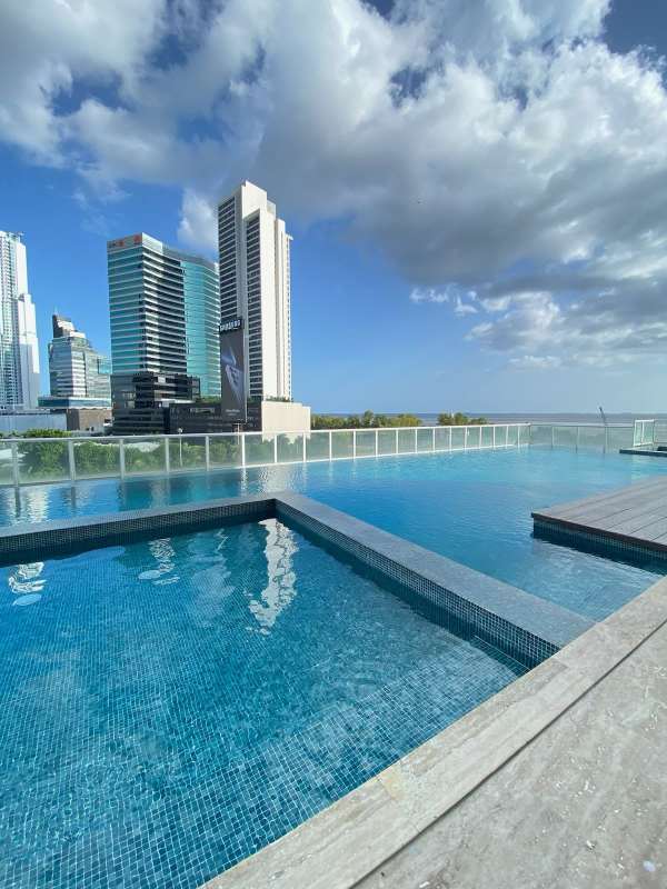 High-rise tower facade with glass balconies, landscaped entrance PH Serenissima Costa del Este Panama