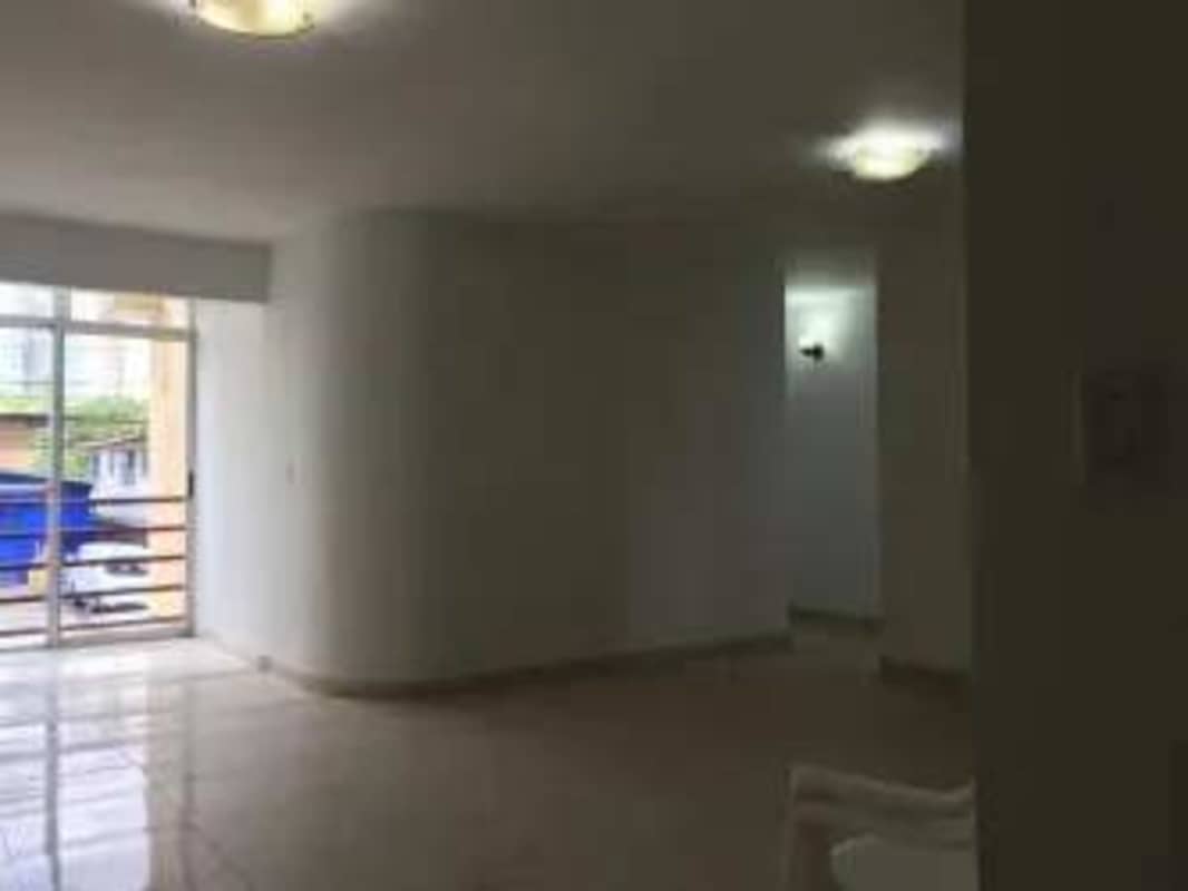 Living and dining area with glossy tiles, sliding glass door to balcony in PH Palmeras del Este Panama City