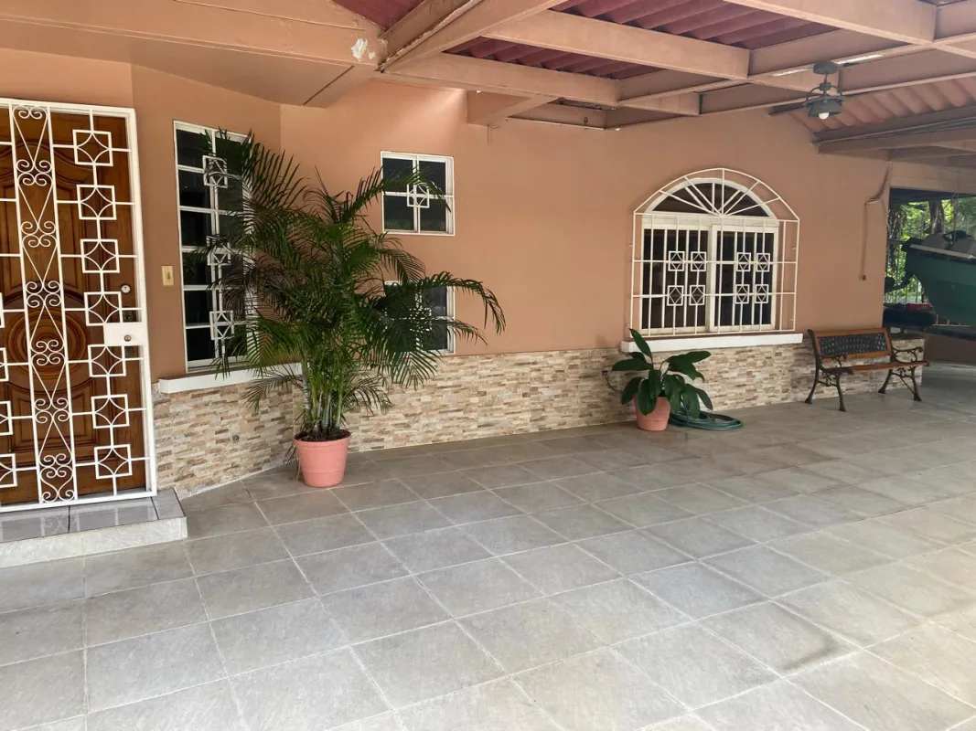 Covered outdoor terrace with potted plants and ceramic tiles in Panama house for sale