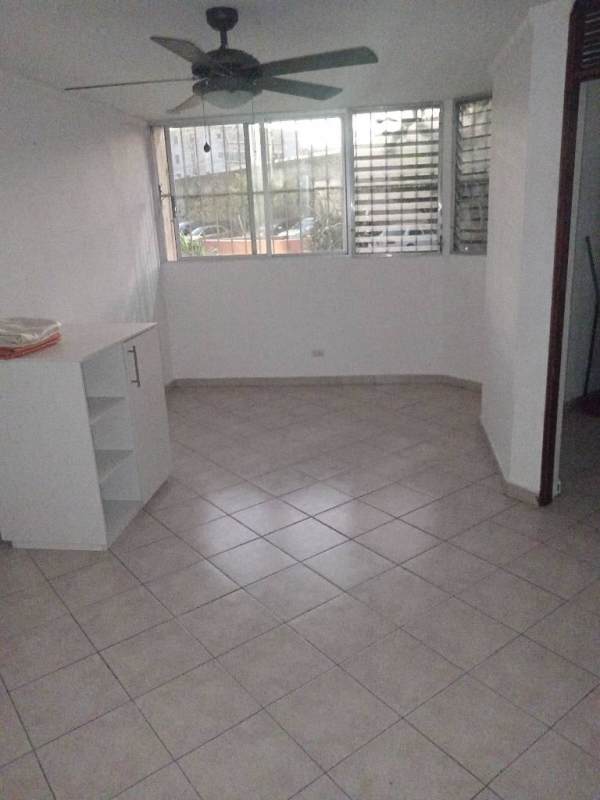 Bedroom with ceiling fan, tiled floor, window with security bars in Parques del Este apartment Panama