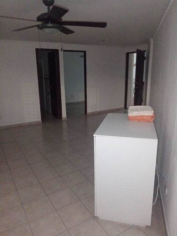 Empty living room with ceiling fan, tiled floor and access to other rooms in apartment for rent Panama