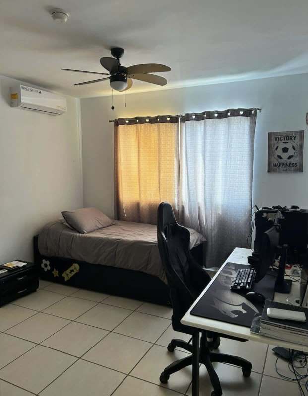 Bedroom with tile floors, ceiling fan, AC, and workspace setup in PH Augusta Brisas del Golf