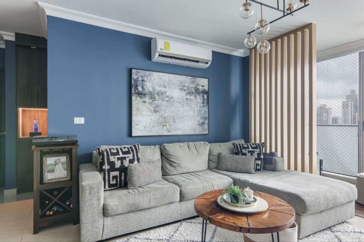 Spacious modern living room with blue wall, sectional sofa, balcony ocean view Pacific Sun Panama