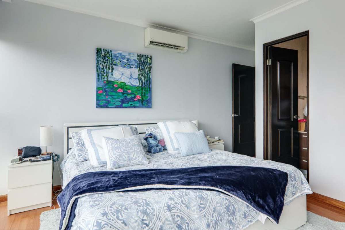 Modern primary bedroom with AC, ensuite bathroom, wood floor in PH Pacific Sun Panama