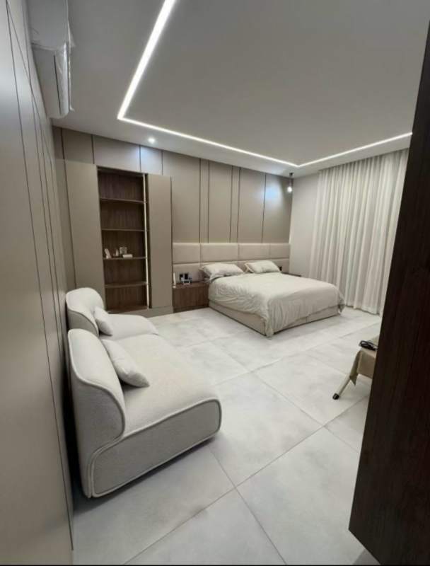 Spacious bedroom with sofas, upholstered bed, wall panels at Santa Maria The Woods