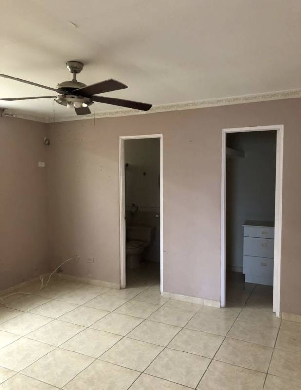 Spacious bedroom with tiled floors, ceiling fan, beige walls in Brisas del Golf Panama City