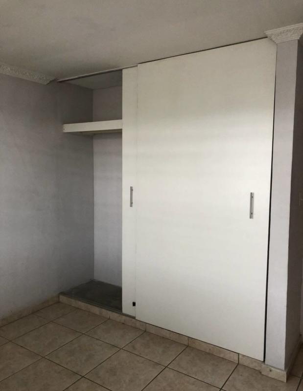 Minimalist bedroom with white sliding closet, tiled floor in Brisas del Golf Panama