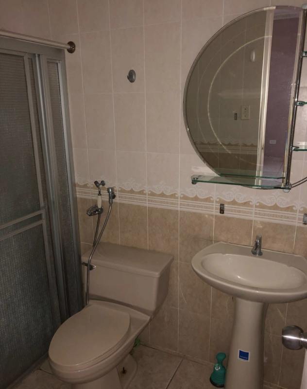 Traditional bathroom with glass-enclosed shower, pedestal sink, beige tiles in Terrazas de Brisas del Golf Panama