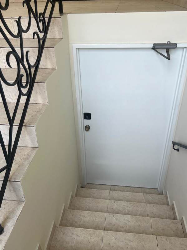 Two-story Mediterranean-style duplex with terracotta roof, covered carport, tropical landscaping Residencial Riviera Colonial Panama