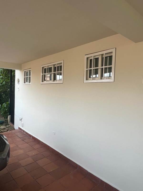 Colonial-style entrance door with sidelights and hanging bell at Residencial Riviera Colonial duplex house Panama