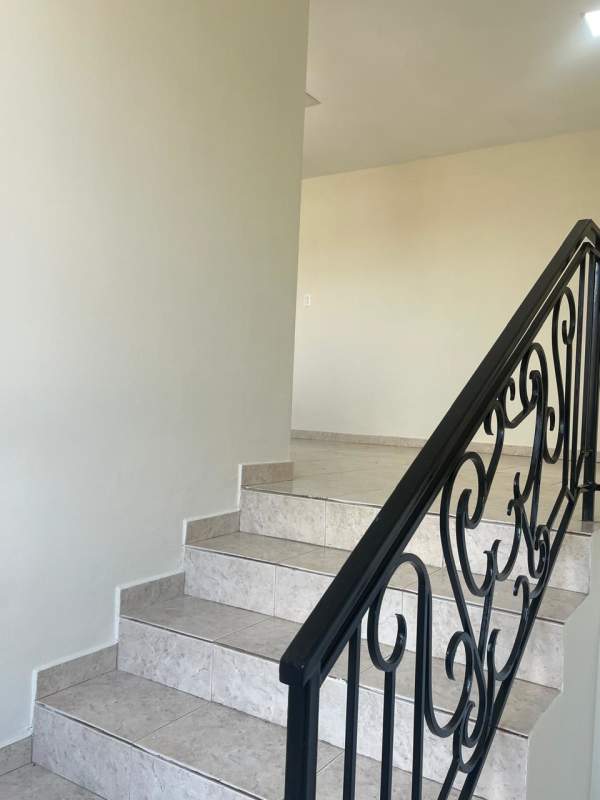 Arched window, iron railing, chandelier on staircase landing duplex house Brisas del Golf Panama