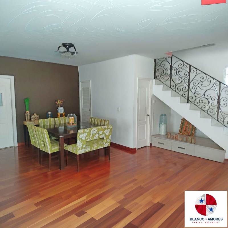 Elegant dining room with wooden floors, contemporary staircase, decorative ceiling lights in luxury house Panama