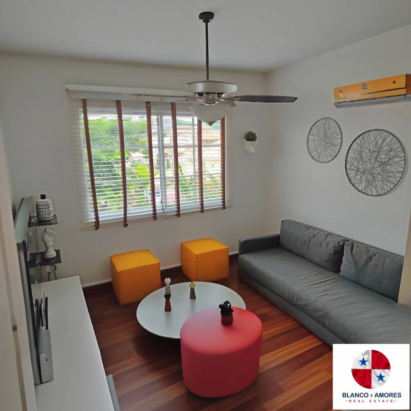 Covered outdoor terrace with sectional sofa, ceiling fan, TV, and garden views in luxury Condado del Rey home Panama