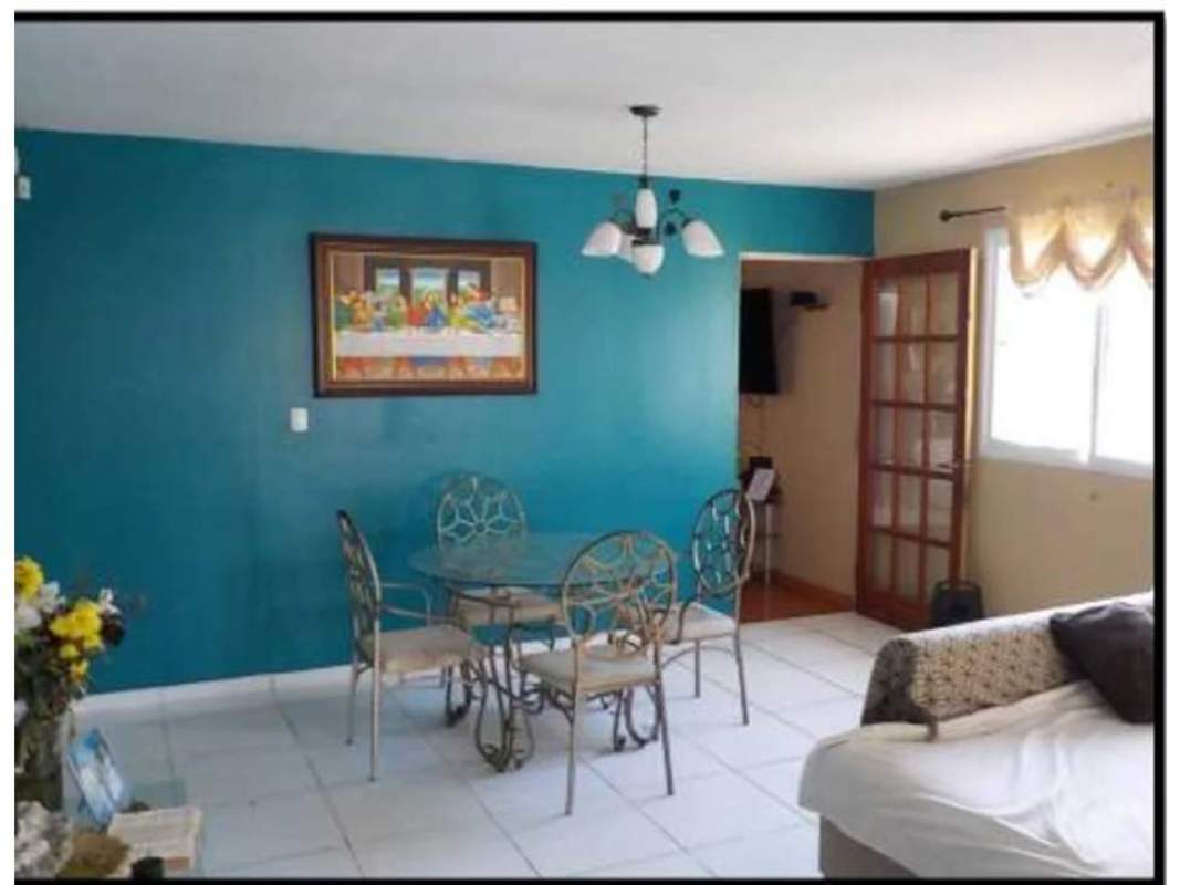 Dining area with glass table teal accent wall and large window Panama house for sale