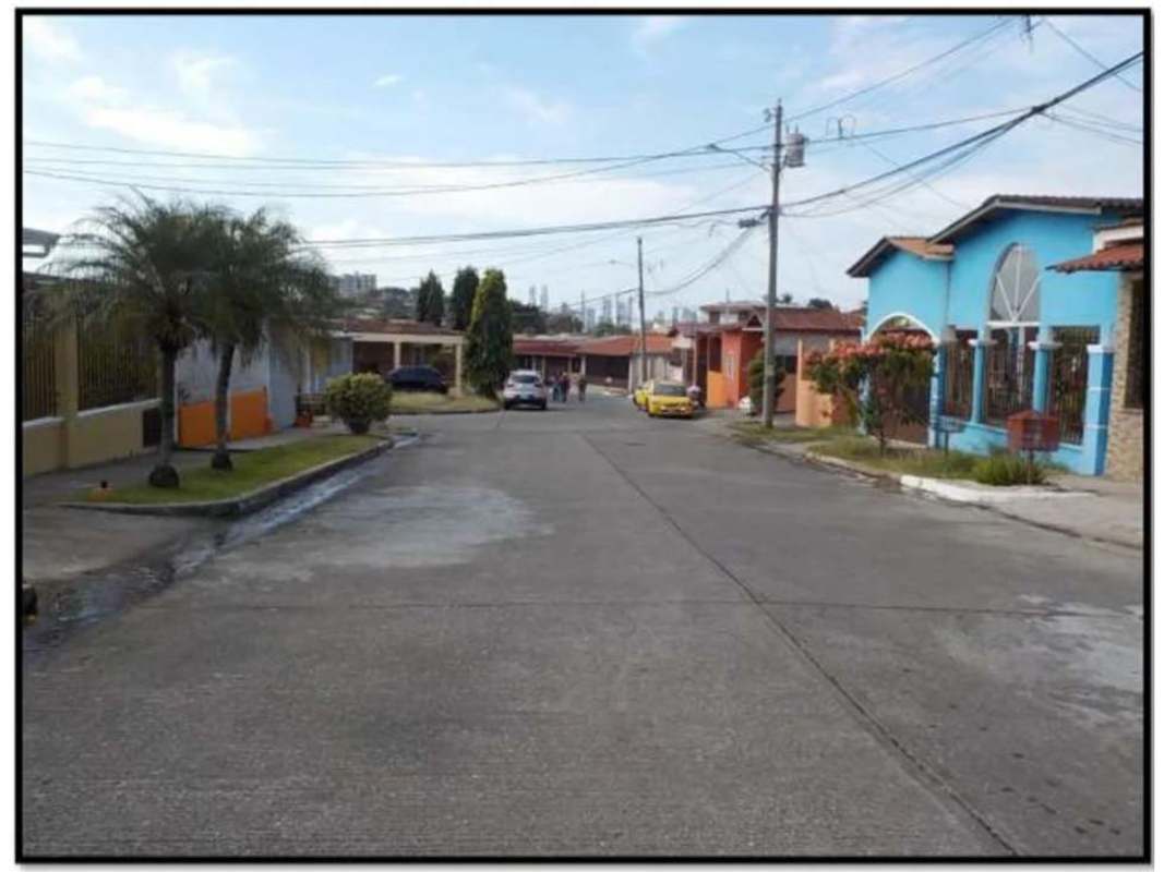 Residential neighborhood street with colorful houses and palm trees in El Crisol Panama