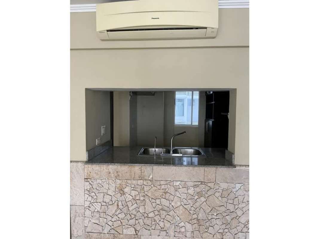 Kitchen area featuring granite top pass-through window, AC, and ceramic floors in PH Cosmopolitan Tower