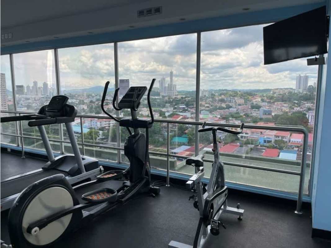 Gym with cardio equipment, large windows, city skyline views at PH Cosmopolitan Tower