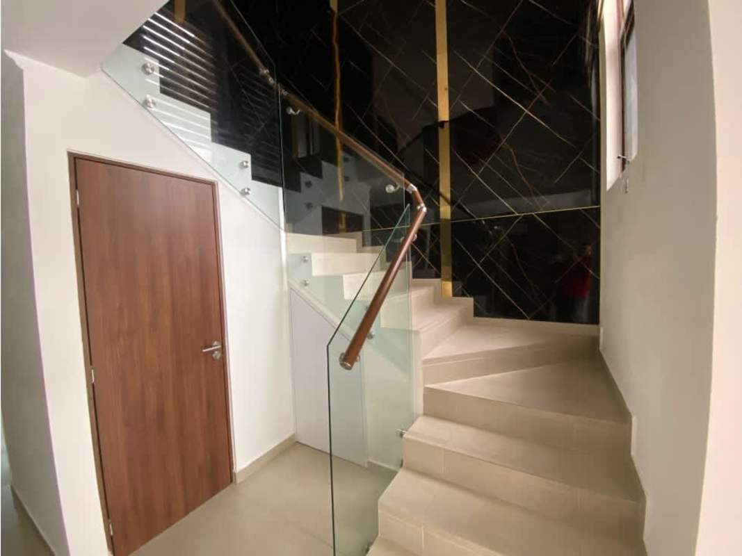 Modern hallway with marble accent wall staircase glass railing PH Gardenias Brisas del Golf Panama