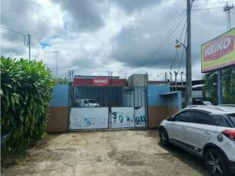 Fenced backyard with grassy open space and concrete warehouse in Terrónal David Panama