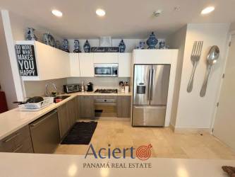 Stylish living space with large windows, modern furniture, connected kitchen Buenaventura beach condo Panama