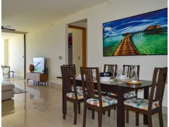 Dining area with large windows partial sea and pool view Casamar PH Perlamar Panama