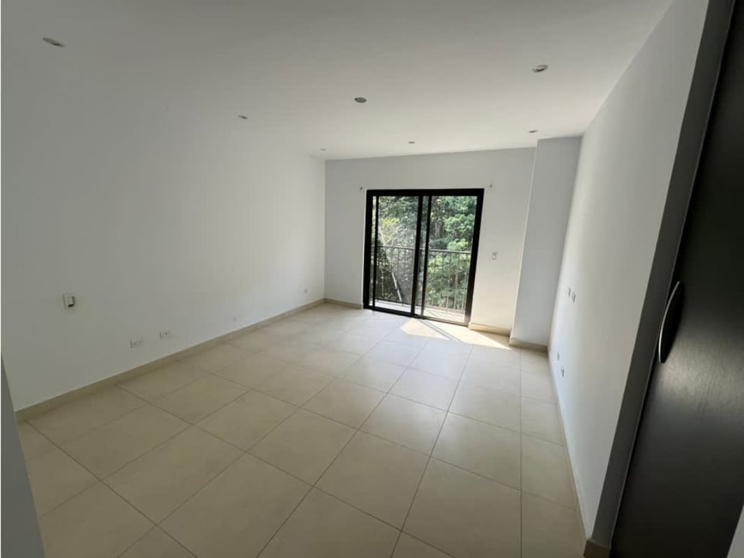 Living room with sliding glass doors and balcony view at PH Embassy Village Clayton Panama City