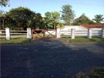Wooden gate and white perimeter fence enclosing property in Coronado Panama