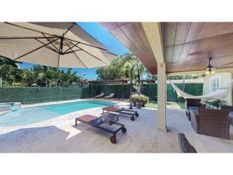 Covered terrace lounge chairs beside pool in private fenced beach home panama
