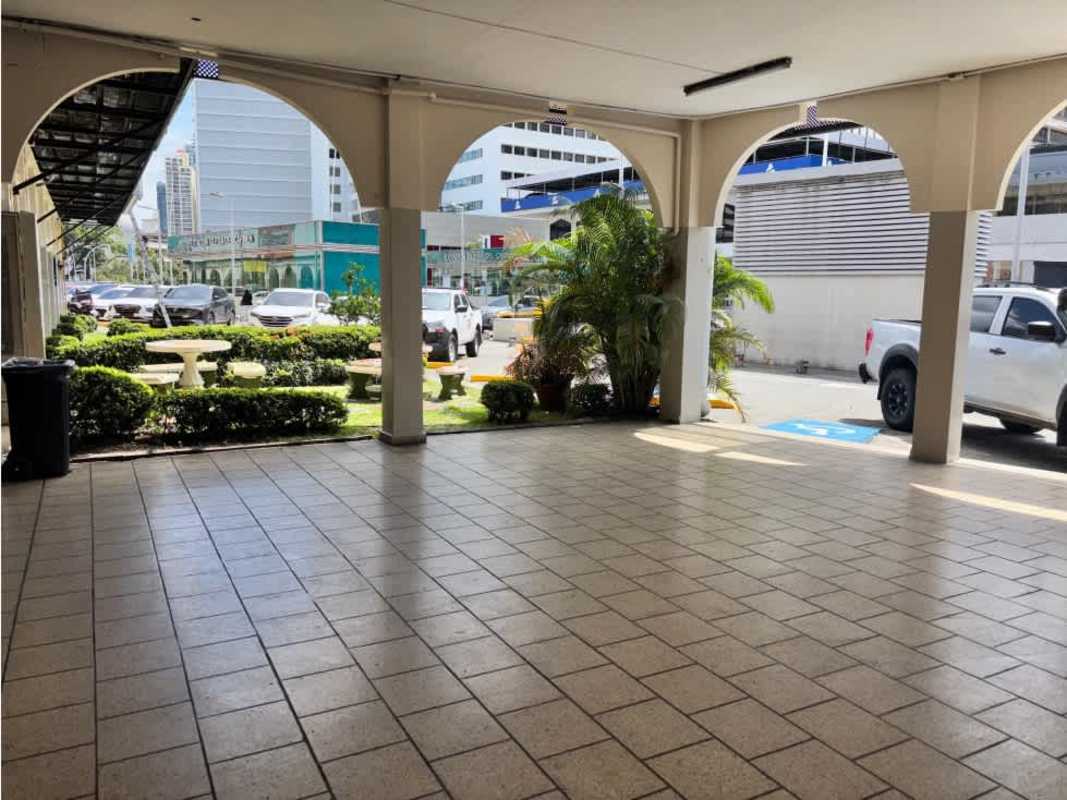 Exterior covered walkway with arches, garden, seating area, and parking in Bella Vista