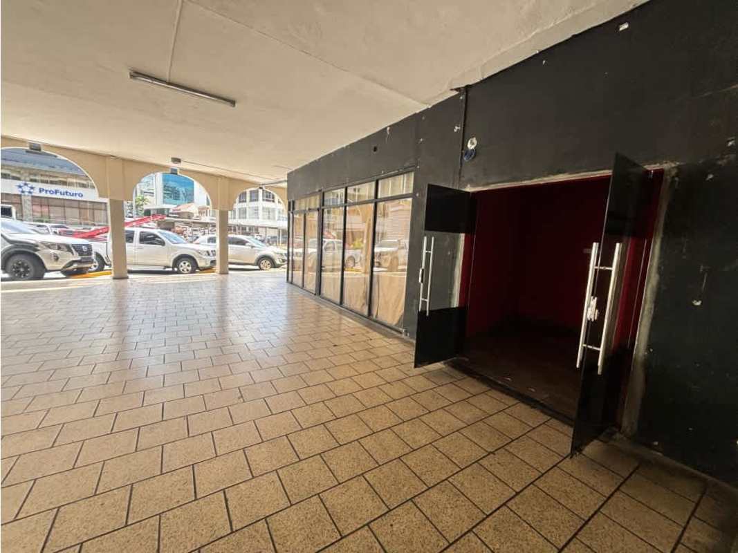 Exterior commercial storefront with glass windows under covered arcade facing traffic on Vía España Bella Vista
