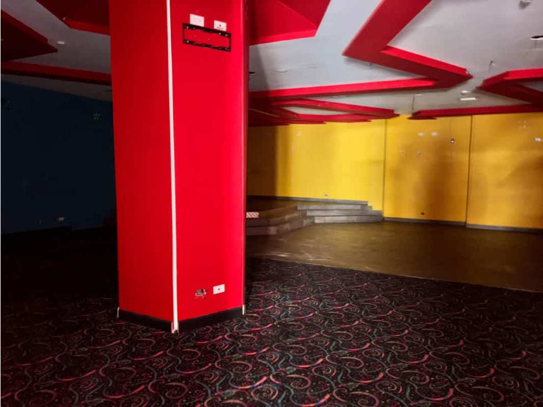 Open commercial interior with colorful accents, patterned floor and ceiling decor near Iglesia del Carmen Metro