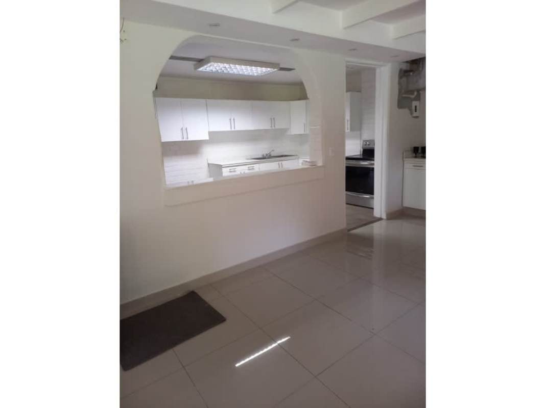 Bright white updated kitchen with modern cabinets and subway tile backsplash in Balboa La Boca Panama