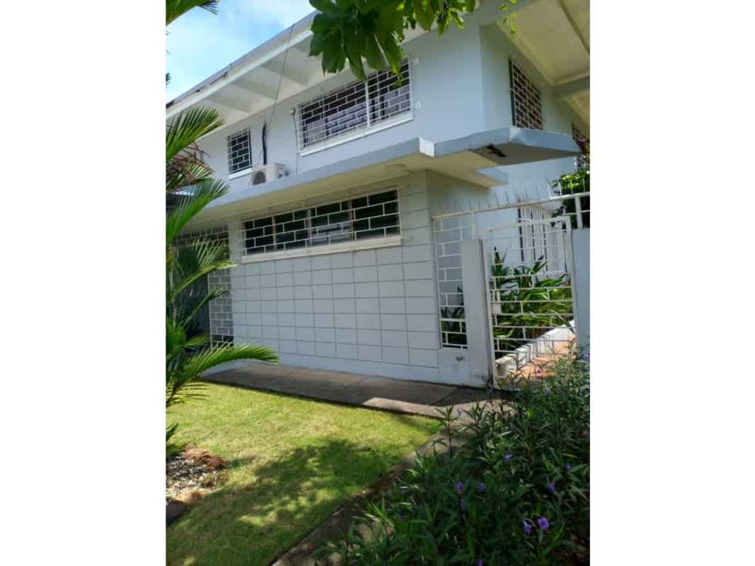 Two-story colonial house facade with green garden and parking in La Boca Panama City