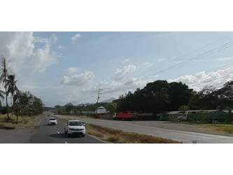 Roadside commercial land with vehicles passing, trees and mountain backdrop Capira Panama