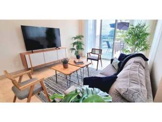 Living room with large windows, modern furniture by marina Buenaventura luxury apartment rental