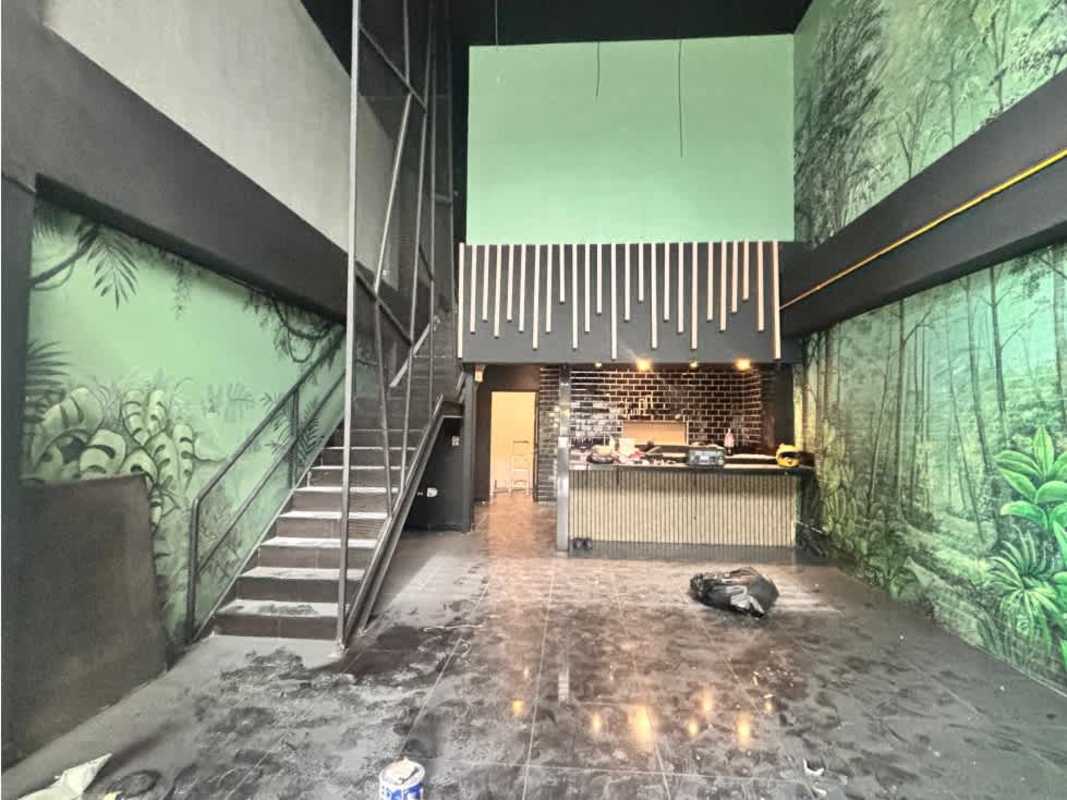 Spacious commercial interior with forest mural, staircase, metal railing at Plaza 74 in San Francisco Panama