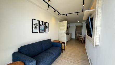 Modern minimalist living room with blue sofa in Playa Caracol beachfront condo Panama