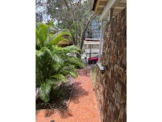 Exterior view garden stone facade house for sale in El Cangrejo Panama