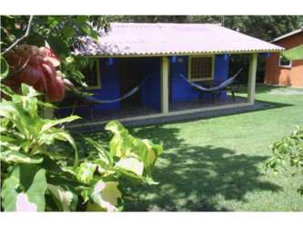 Colorful tropical cabins with porch hammocks and garden views at Playa Corona hostel Panama