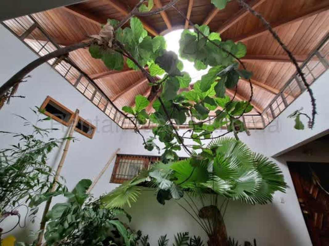 Spacious kitchen with wood cabinets, tiled backsplash, and dining area in Betania Panama house for sale