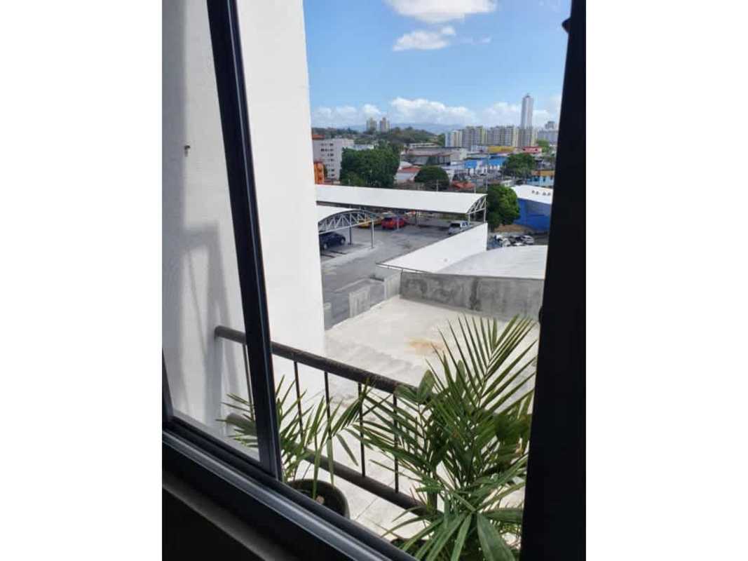 Living room with balcony glass doors, wooden floor effect tile and ceiling fan in PH Lefevre 75 Panama