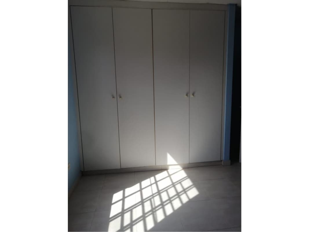 Bedroom with light walls and wood look floor in Portal de las Cumbres Villa Zaita Panama