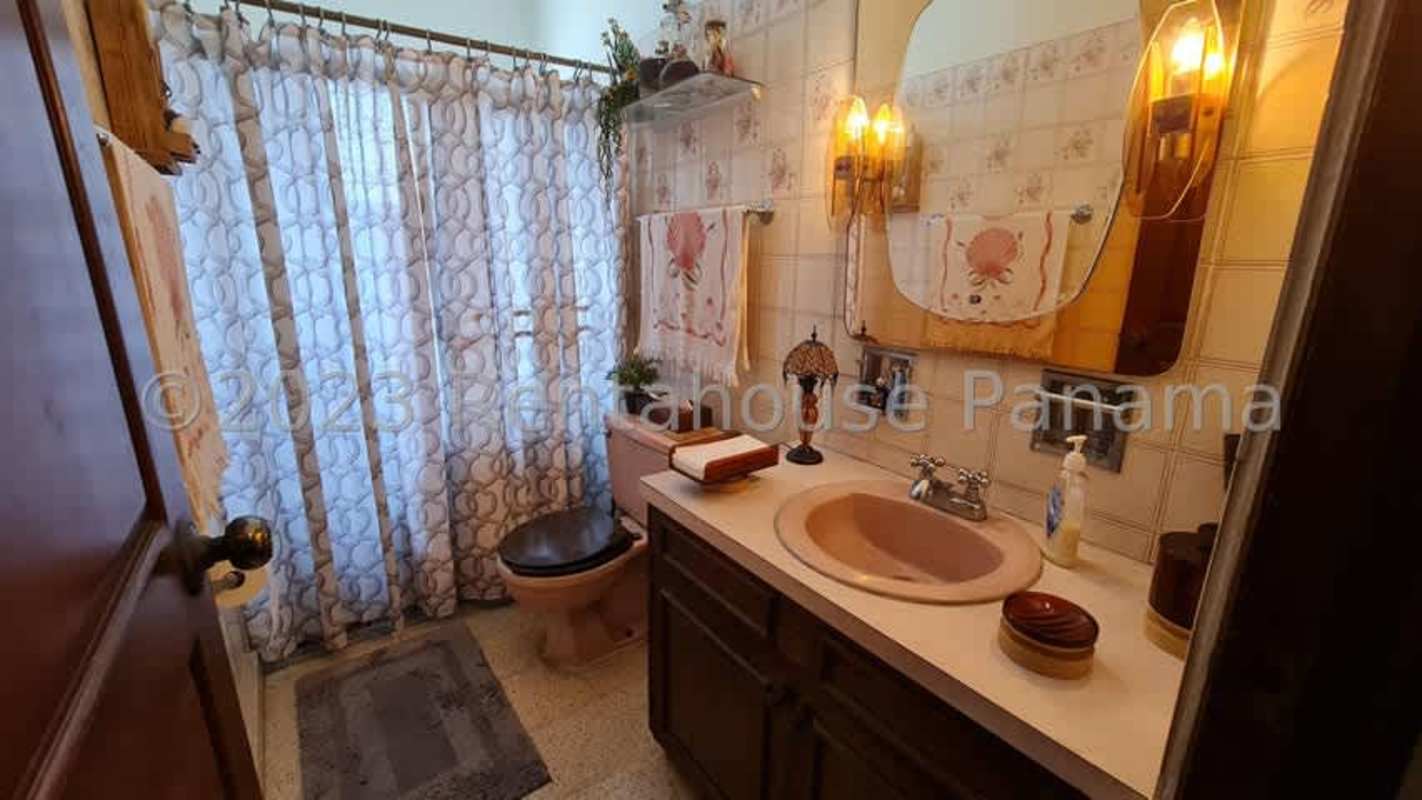 Spacious traditional bedroom with wooden bed, seating, floral decor in Hato Pintado Panama