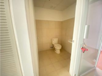 Minimalist beige tiled bathroom with white sink and toilet for office in Plaza Korintho El Carmen