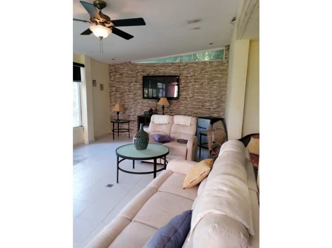 Spacious living room with stone accent wall, ceiling fan, large windows Cerro Azul Panama